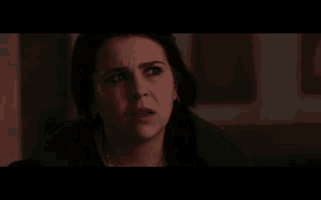 a woman is screaming with her mouth wide open in a dark room