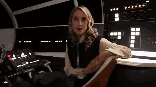 a woman is sitting in a chair in front of a control panel that says ' a ' on it