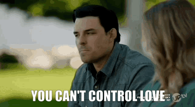a man and a woman are sitting in a park and the man is saying you can 't control love .