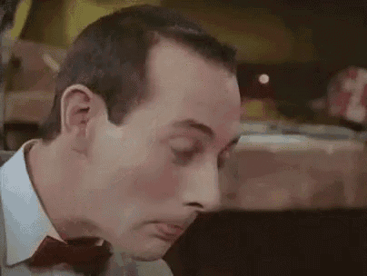 a man wearing a bow tie is making a surprised face .