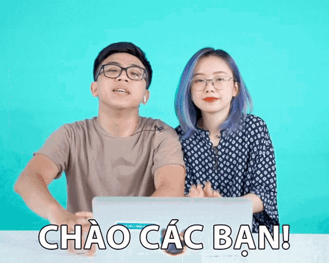 a man and a woman are sitting at a table with a laptop and the words chao các ban
