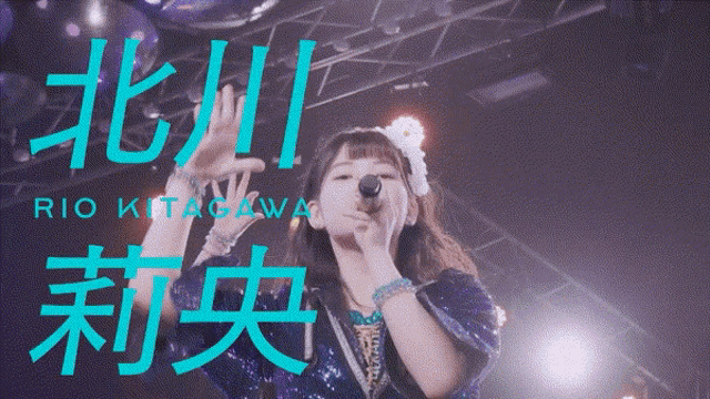a girl singing into a microphone with the name rio kitagawa written on the bottom