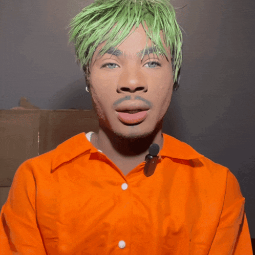 a man with green hair and an orange shirt