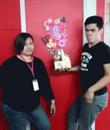 a man and a woman are standing in front of a red door with a bunny on it