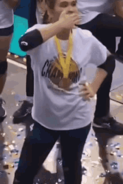 a woman wearing a white shirt that says champions on it