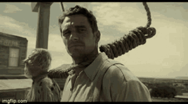 a man with a rope around his neck is standing next to another man .