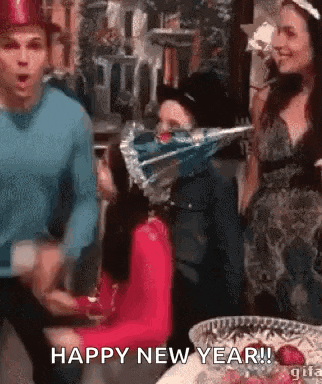 a group of people are dancing at a new year 's eve party and a woman is wearing a party hat .