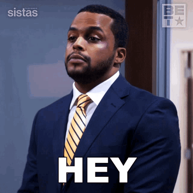 a man in a suit and tie says hey in white letters