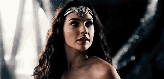 a close up of a woman wearing a wonder woman costume and looking at the camera .