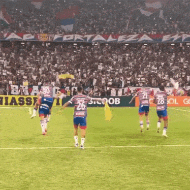 a group of soccer players on a field with the number 26 on their jersey