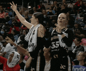 a female basketball player wearing a number 35 jersey stands in front of a crowd
