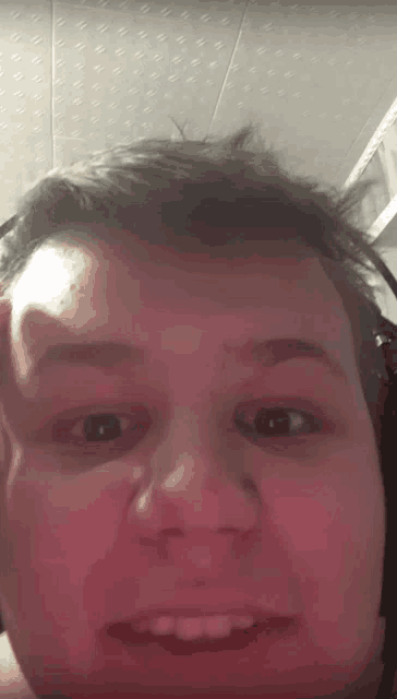 a close up of a man 's face with a headset on