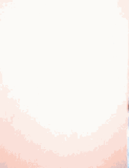 a woman with long hair is peeking over a white wall