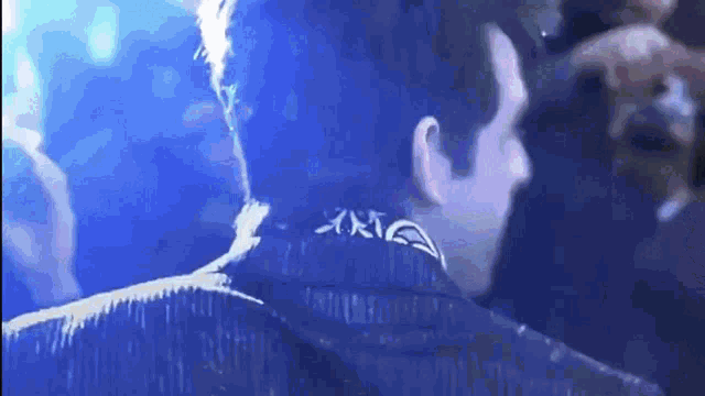 a man wearing a blue jacket with a x on the back of his neck