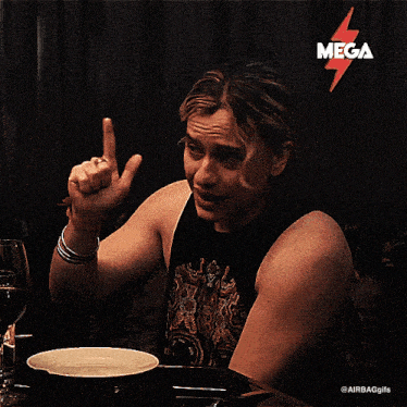 a man sitting at a table with a mega sticker on the top