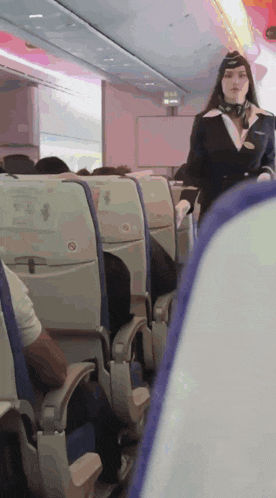 a woman in a flight attendant uniform stands in a row of seats
