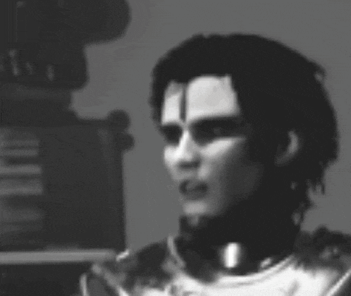a black and white photo of a man in a knight 's armor with a cross on his forehead .