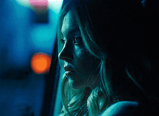 a close up of a woman looking out a car window