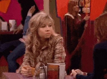 a girl in a plaid shirt sits at a table with a menu on it