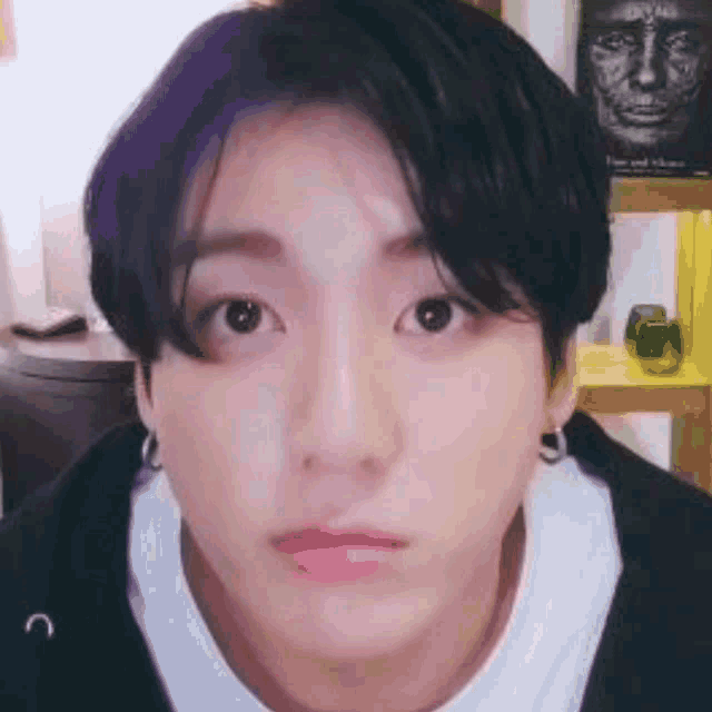 a close up of a person 's face with a pink lip and earrings .