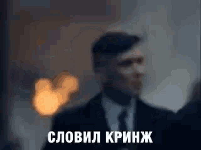 a blurry picture of a man in a suit and tie standing in front of a building .