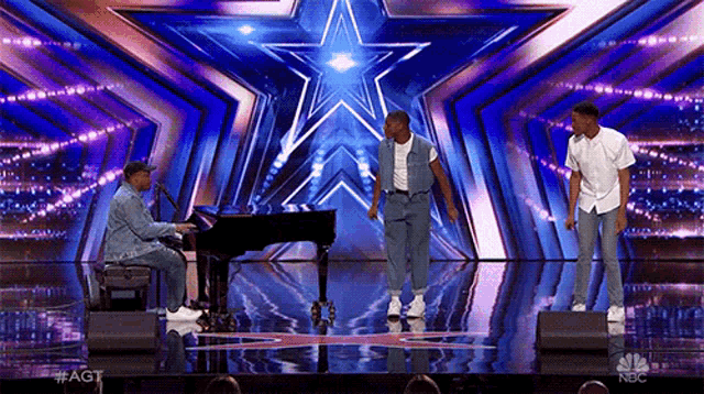 a man playing a piano while two men dance on a stage