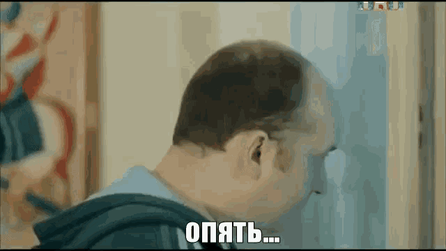 a man is standing in front of a door and looking out of it .