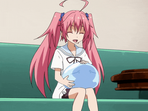 a girl with pink hair is sitting on a green couch
