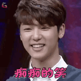 a young man in a suit and white shirt is smiling with chinese writing on his face .