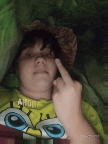 a person wearing a spongebob shirt giving a middle finger