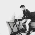 a man is sitting in front of a desk with a laptop on it .