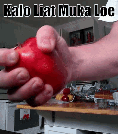 a person is holding a red tomato in their hands with the words kalo liat muka loe above it