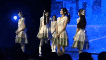 a group of young girls are standing on a stage .