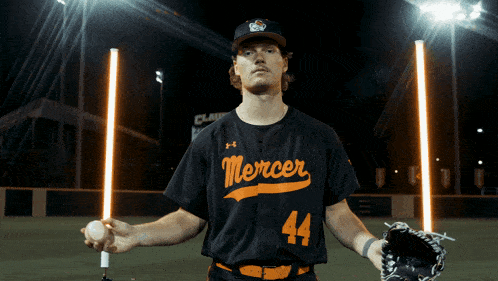 a mercer baseball player holding a ball and glove
