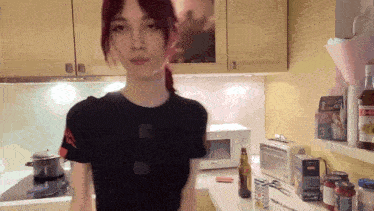 a woman standing in a kitchen with a box on the counter that says ' 3 ' on it