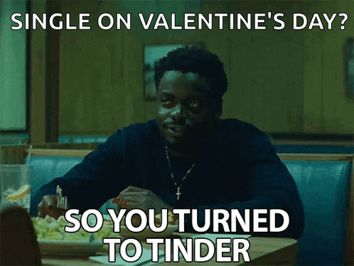 a man is sitting at a table with a plate of food and the words single on valentine 's day