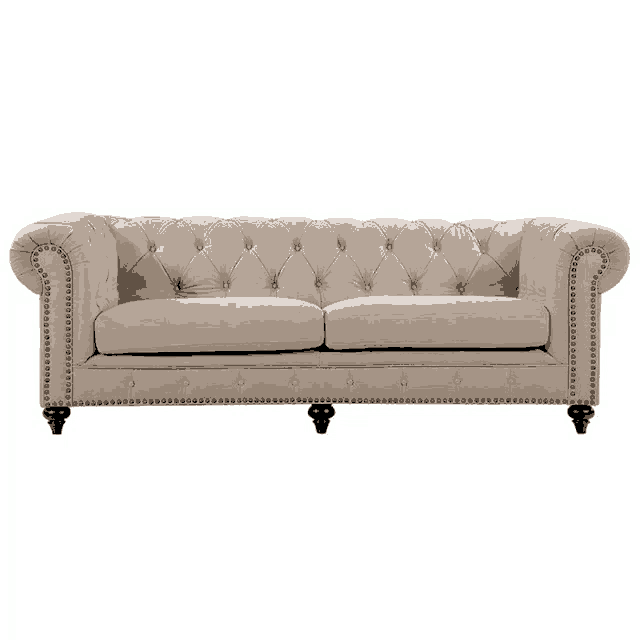 a beige tufted couch with studs on the legs
