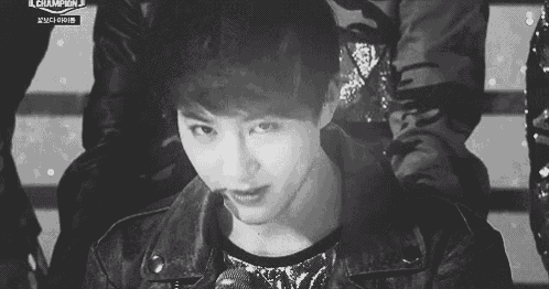 a black and white photo of a young man holding a microphone .