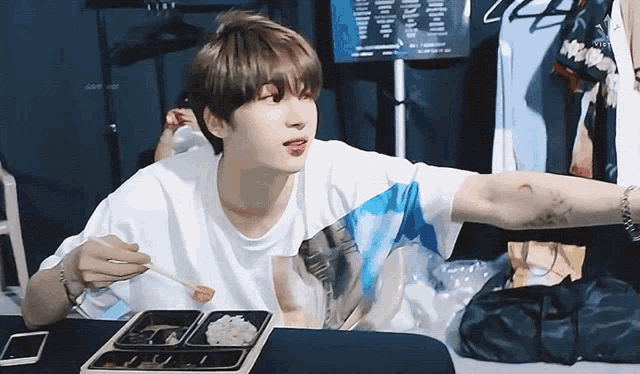 a man with a tattoo on his arm is eating food