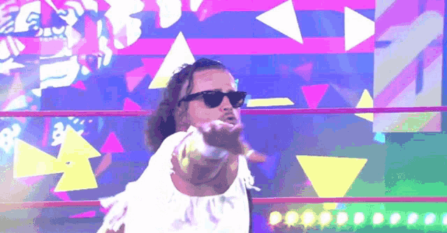 a man wearing sunglasses and a white shirt is dancing