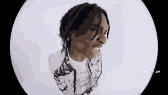 a man with dreadlocks is making a funny face in a video .