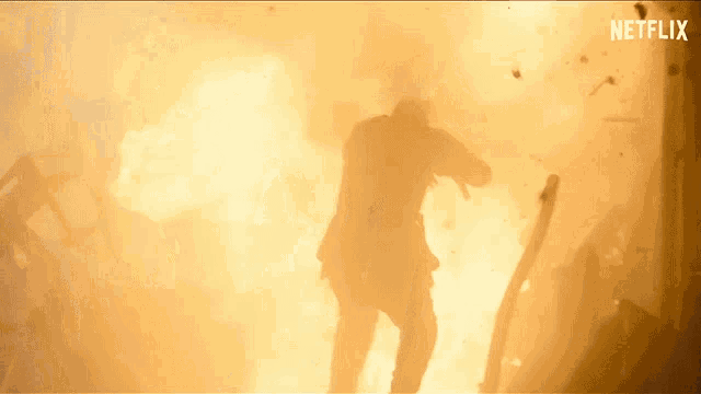 a man in a suit is standing in front of a large explosion with netflix written on the bottom