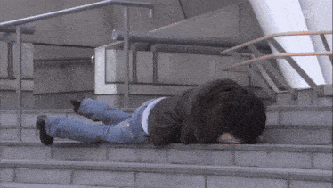 a person laying on a set of stairs with a bsn logo on the bottom right