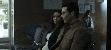a man and a woman are sitting in a dark room