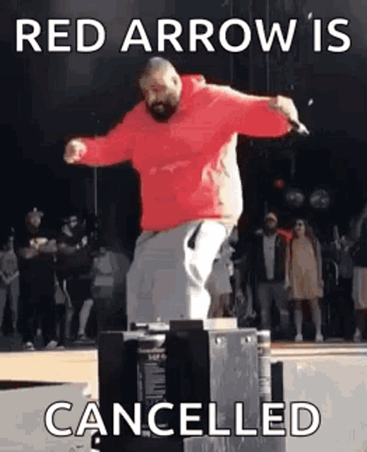 a man in a red hoodie is dancing on a stage with a microphone .