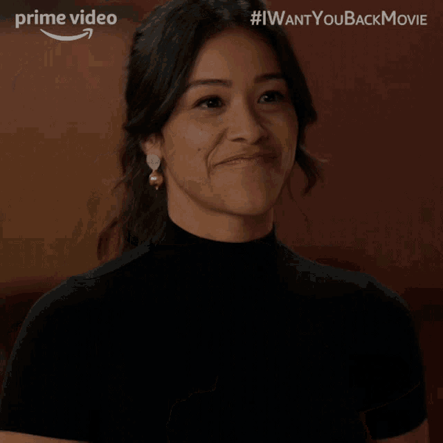 a woman is smiling in front of a sign that says i want you back movie