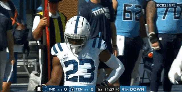 a football player with the number 23 on his jersey stands on the field