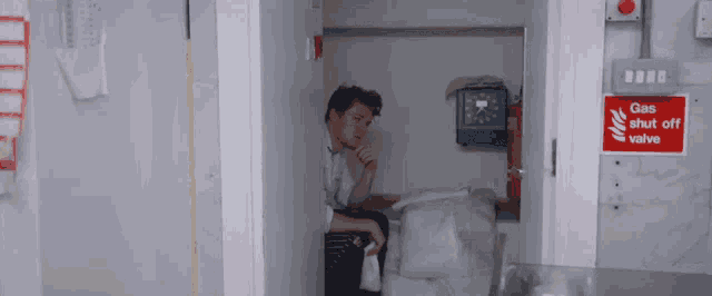 a man sits in a room with a gas shut off valve