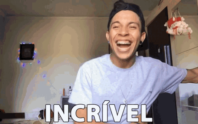 a man in a white shirt is laughing with the word incrivel written on his shirt