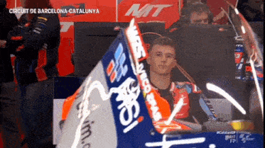 a man sitting in front of a computer with circuit de barcelona catalunya written on the bottom